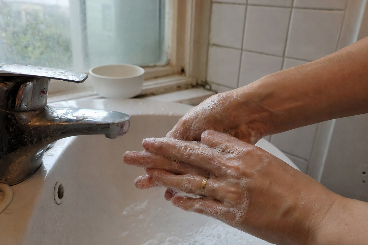 bright vibrant photorealistic close-up of clear gel cleanser foam on hands beside a sink with white tiles and soft sunlight, no visible labels, no Korean text