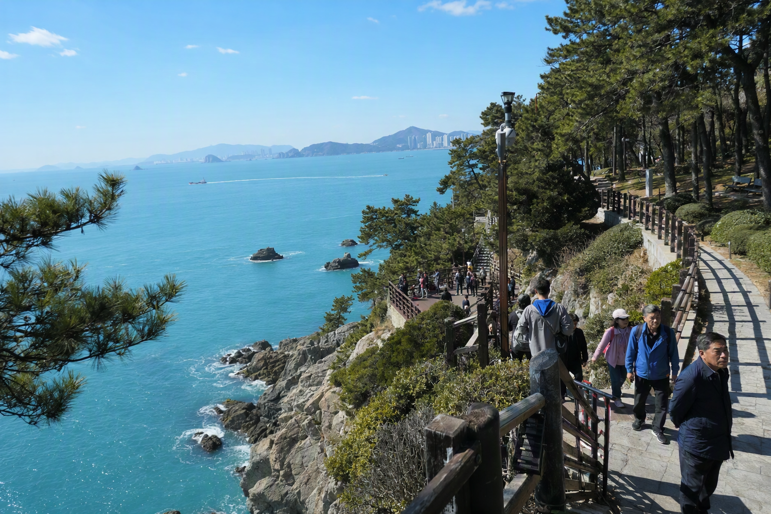 Bright photorealistic coastal cliff park in Busan with deep blue ocean, rocky edges, pine trees, walking path, clear sky, no visible text