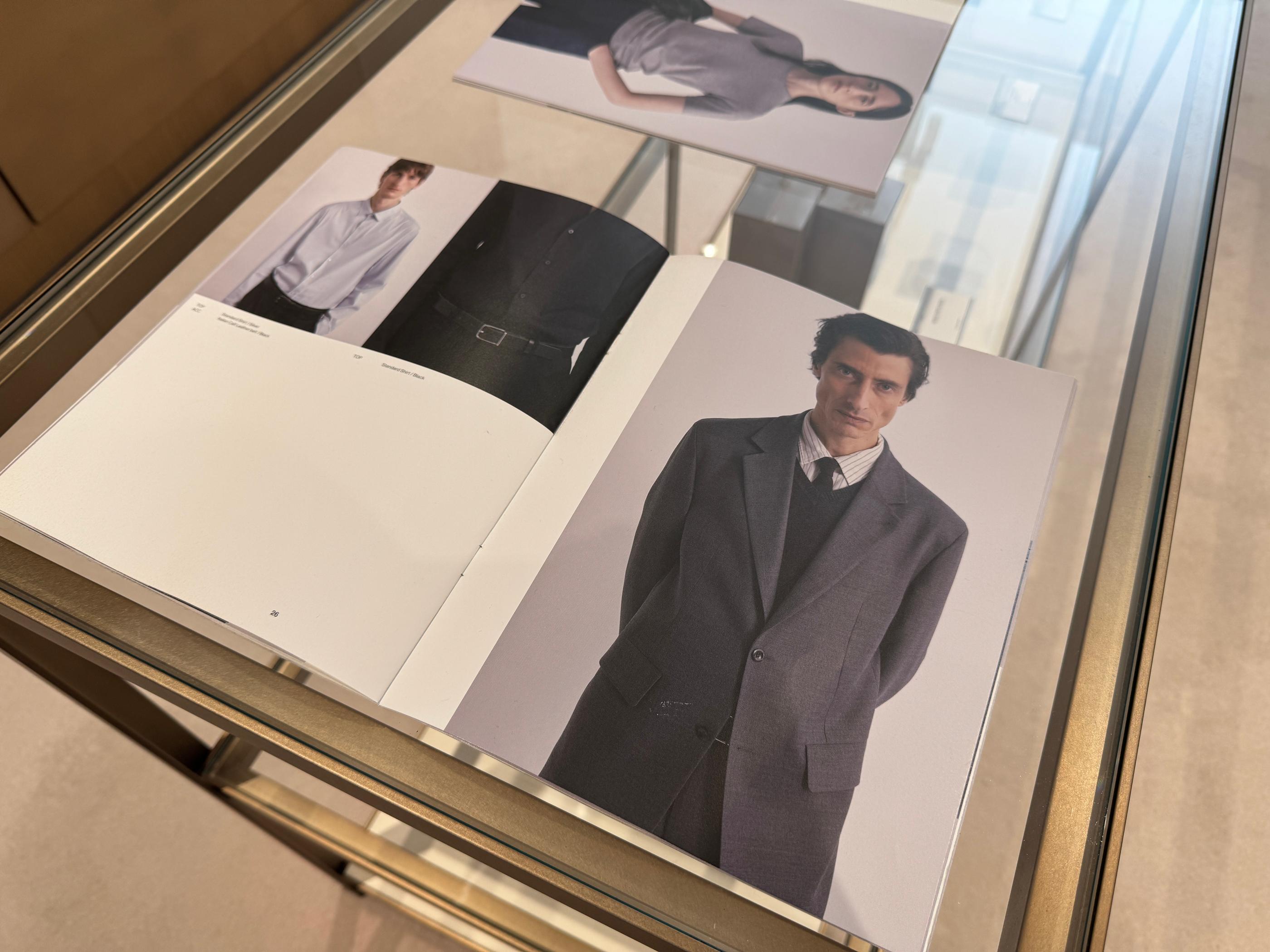 Open Pottery lookbook catalog on a wooden display table showing styled outfit photos from the current collection