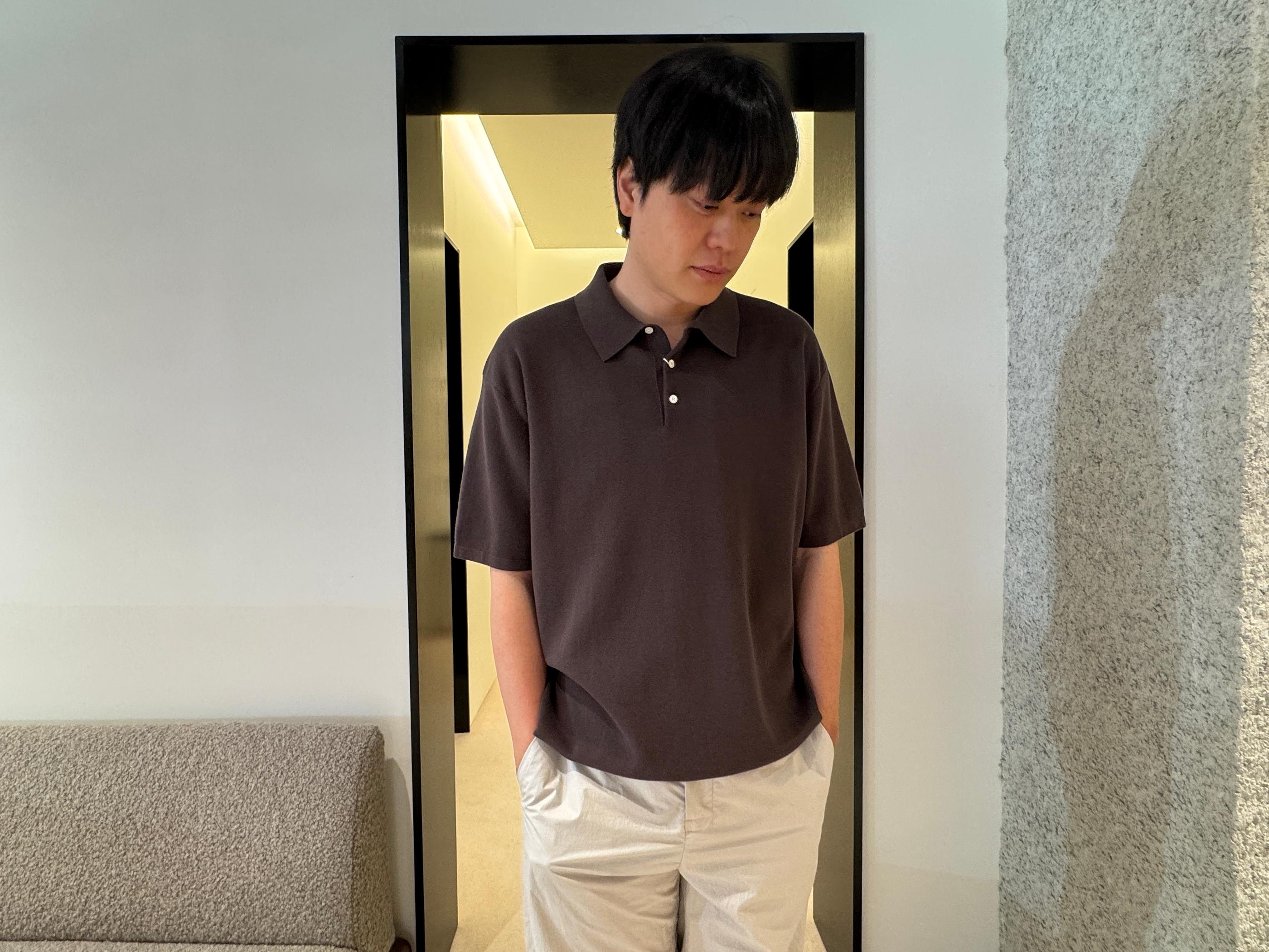 Man with blurred face modeling a dark brown knit polo and off-white wide-leg trousers inside Pottery Seongsu store, showcasing the brand’s minimalist, relaxed Korean menswear fit.