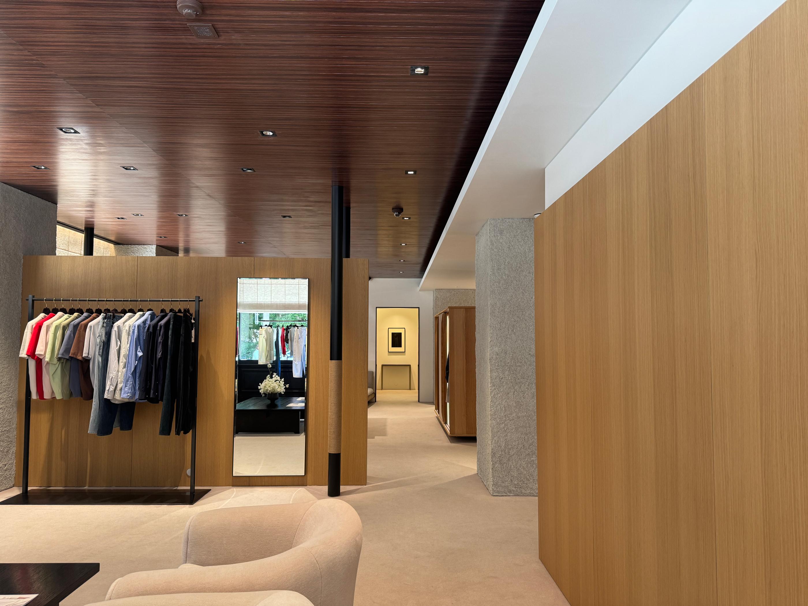 Inside Pottery’s Seongsu store in Seoul: minimalist wooden interiors, a spacious fitting area, and display racks that reflect the brand’s organized, comfortable Korean menswear shopping space