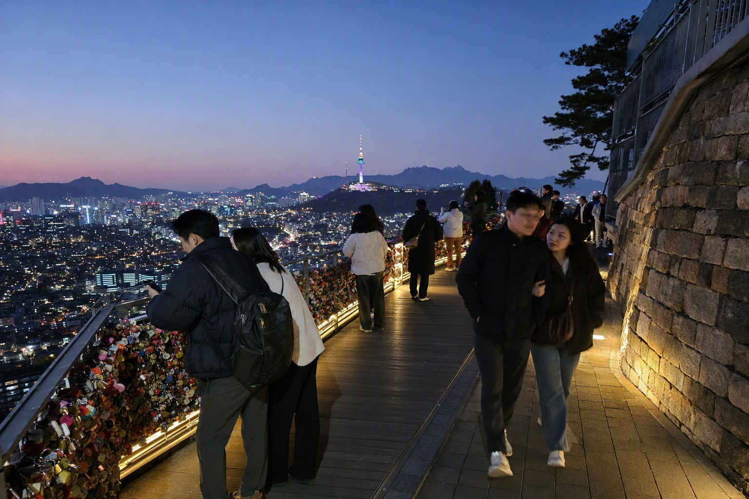 N首爾塔的逼真繽紛夜景, 下方城市燈火璀璨, 情侶與朋友走在愛情鎖欄杆旁, 晴朗天空, 無文字