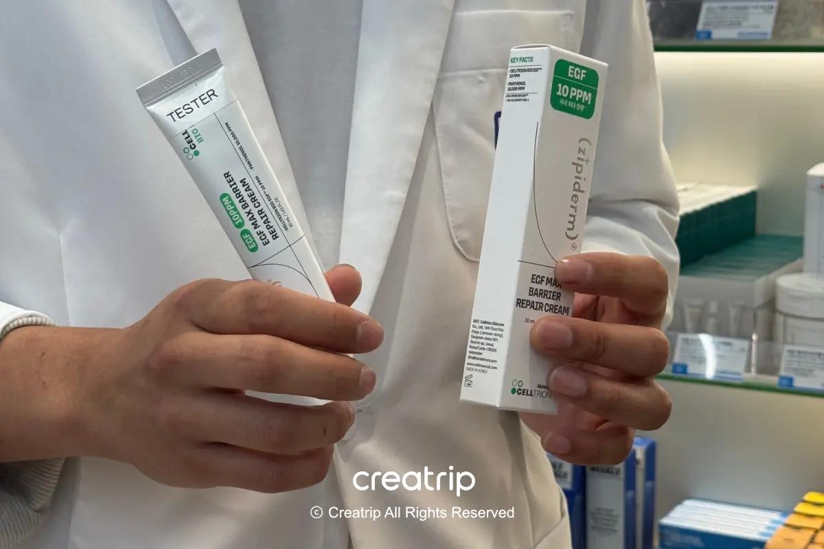 穿著白袍的職員拿著zipiderm EGF Max Barrier Repair Cream盒裝與試用裝的樣子
