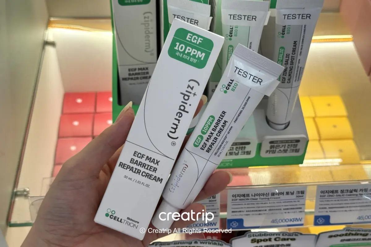 在藥局貨架前拿著zipiderm EGF Max Barrier Repair Cream盒子的樣子