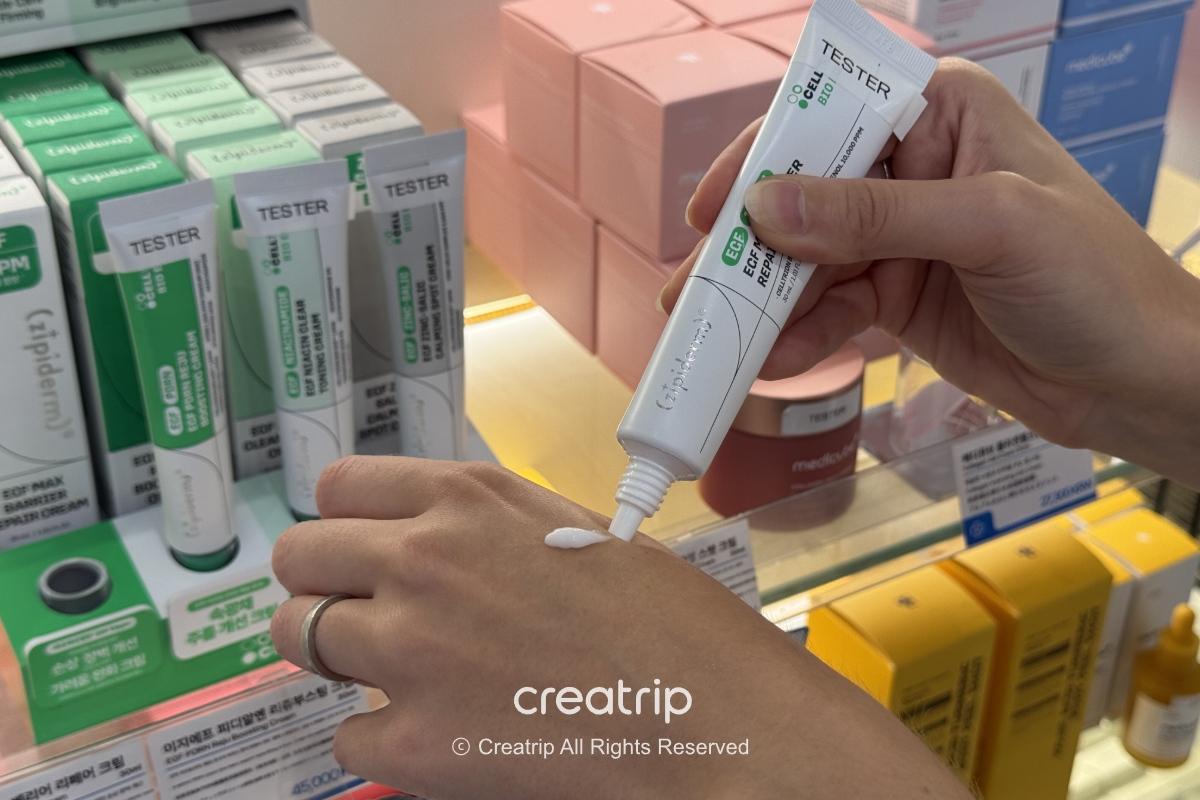 Cream dispensed on the back of a hand and the Zipiderm EGF Max Barrier Repair Cream tube