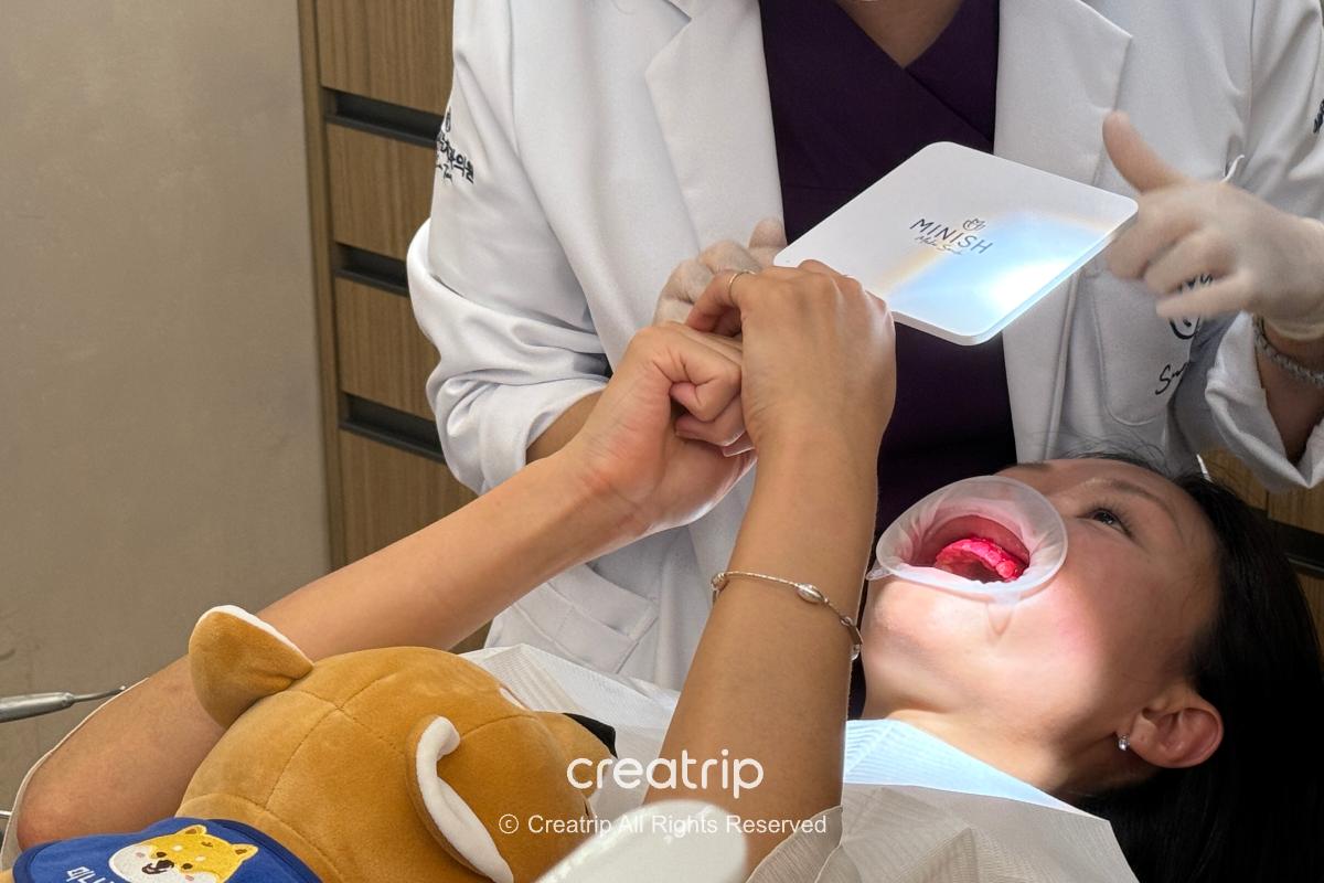 Checking the teeth with a hand mirror