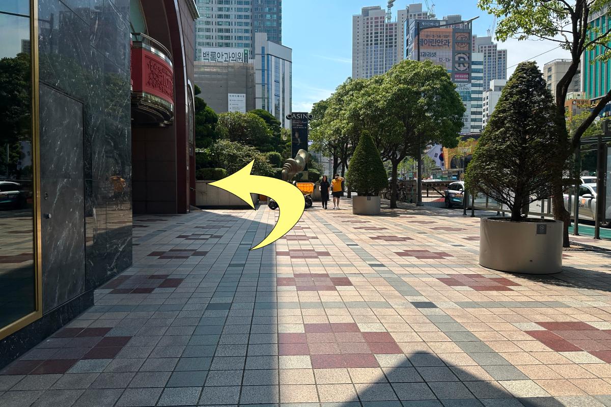 Wide tiled sidewalk with an arrow pointing left