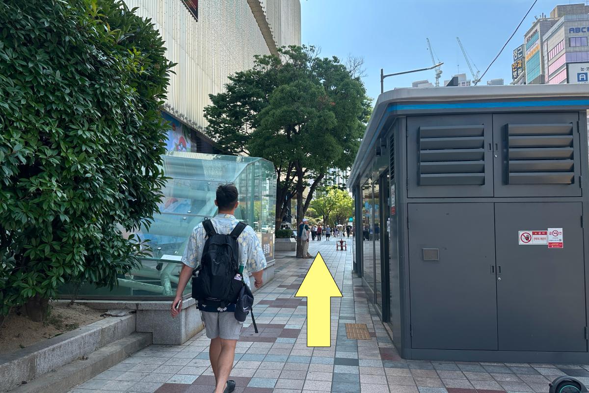 Pedestrian route beside a wall and service structure