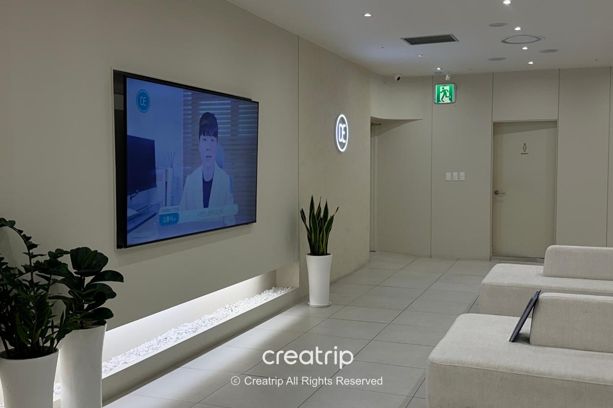 Bright white waiting area with bench seating and wall display