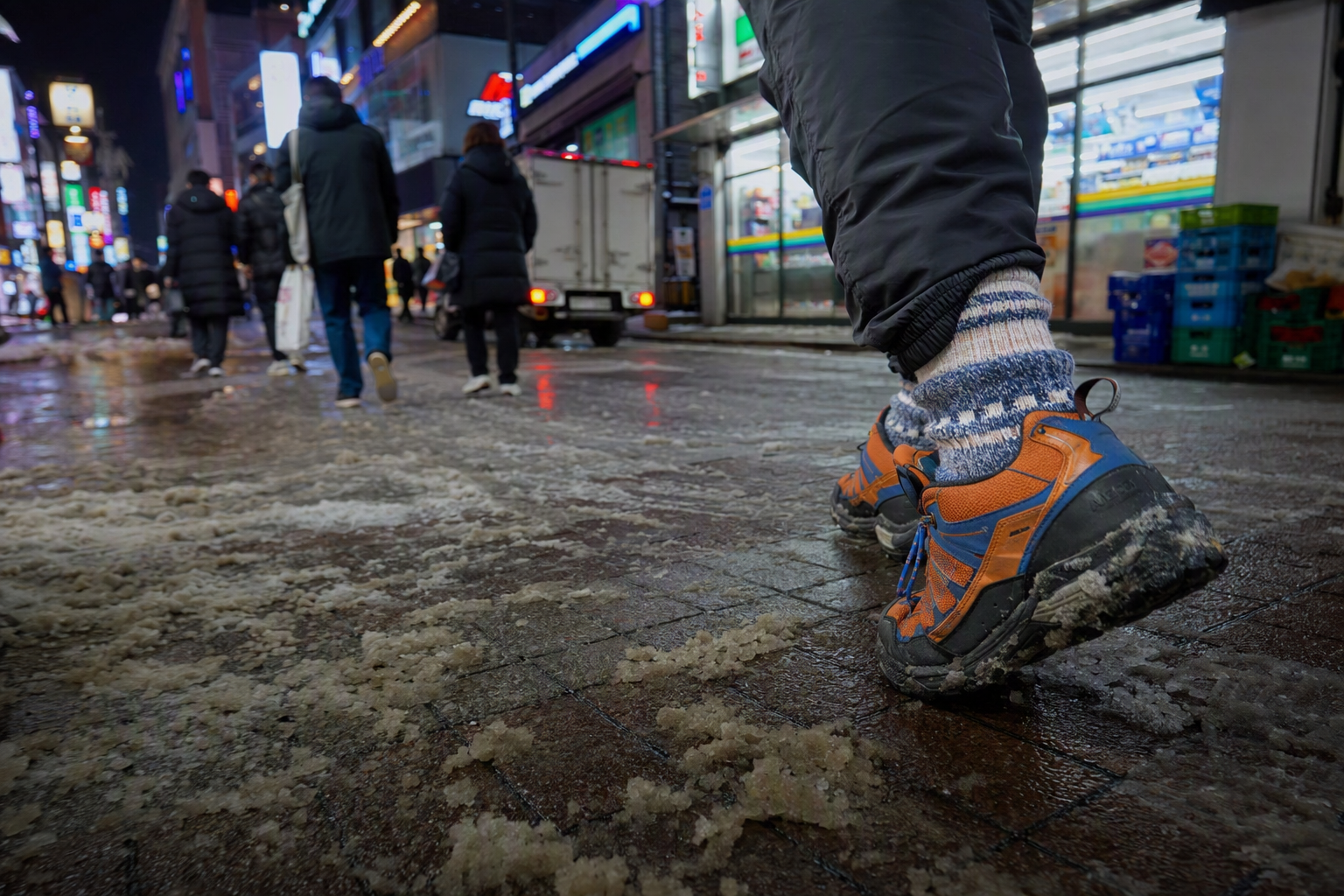 Bright vibrant photorealistic winter boots walking on an icy Seoul sidewalk, warm socks, city lights, no visible text