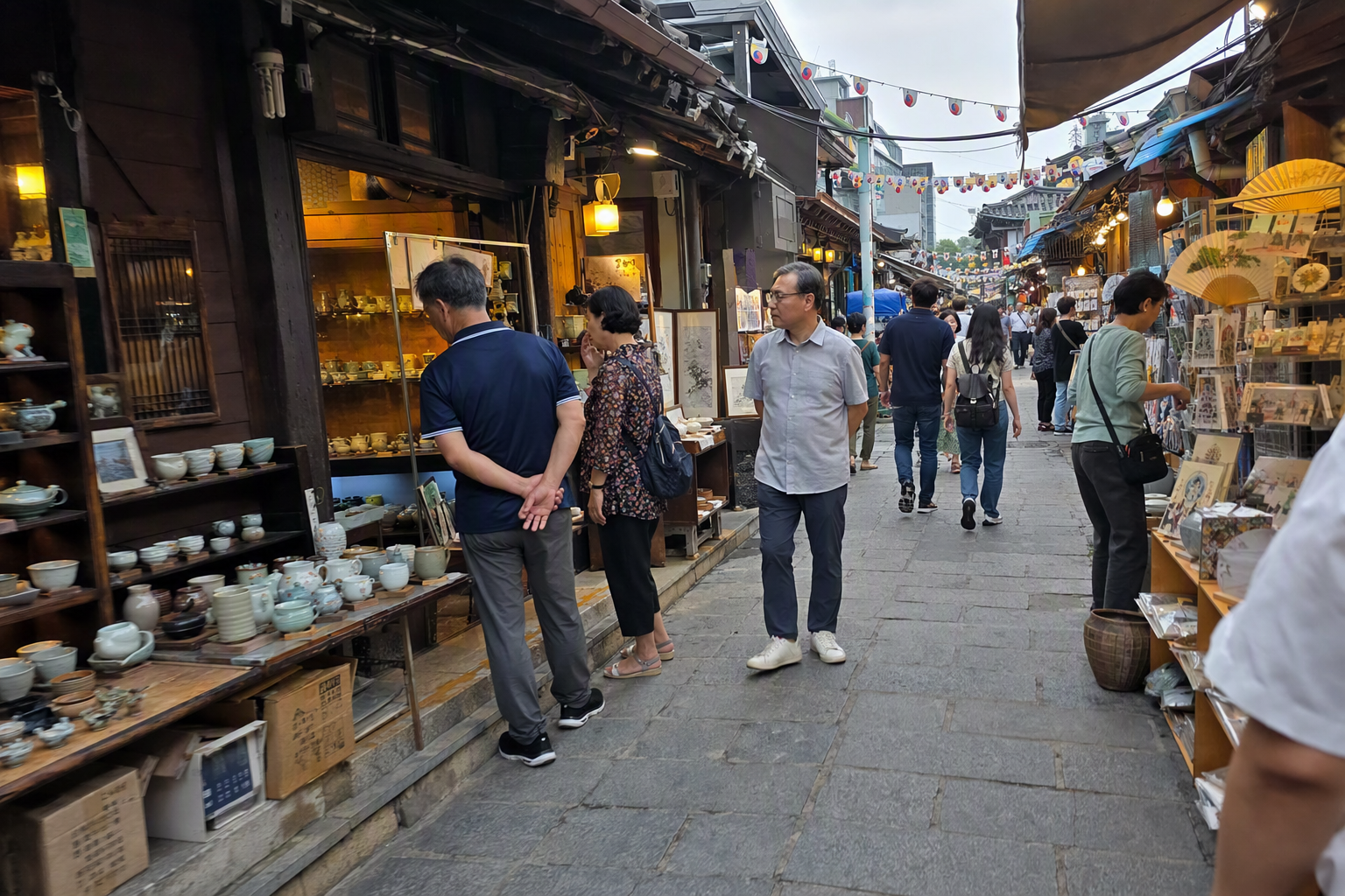明亮鮮活、寫實風格的仁寺洞巷弄, 有傳統工藝店、茶館入口、燈籠, 行人逛著陶器與紙品, 無韓國字樣