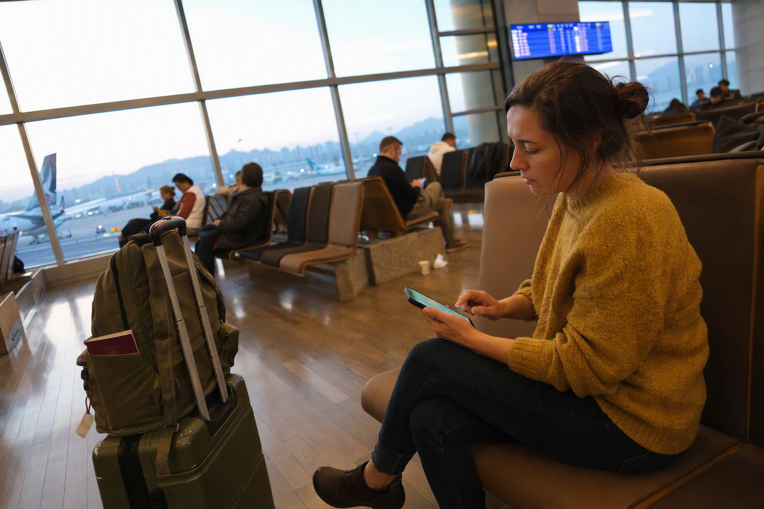 Bright vibrant photorealistic image of a traveler using a smartphone at an airport lounge, digital entry form concept, suitcase beside them, no readable text