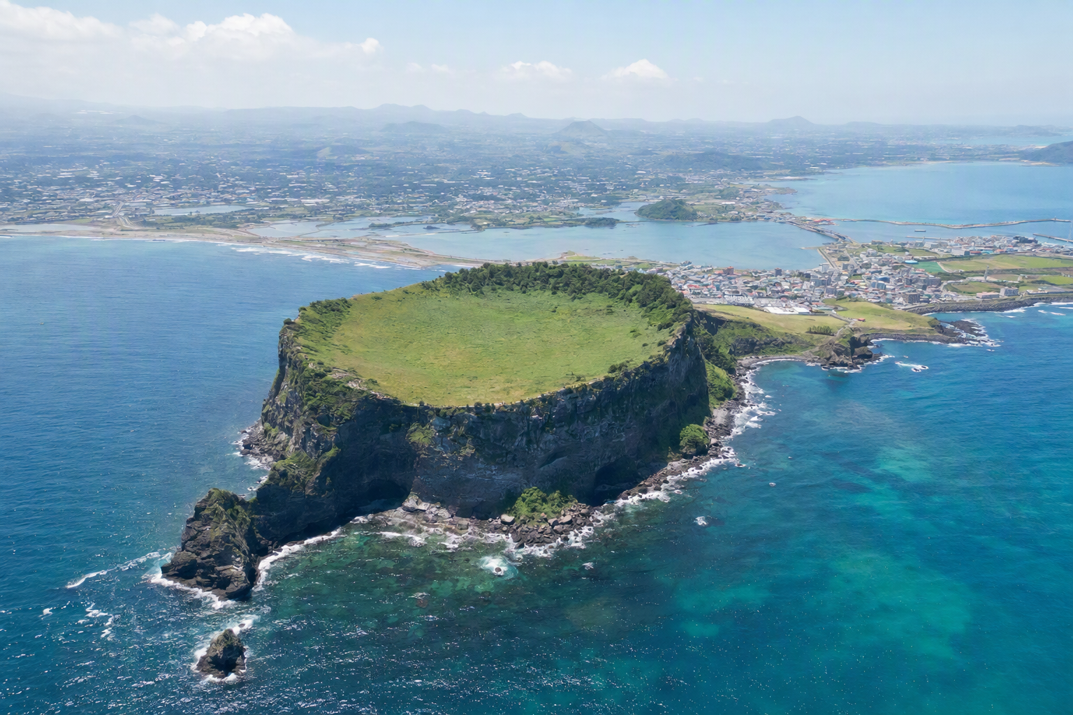 濟州島城山日出峰旁的航拍景色，綠松石色海面，清晨光線明亮、色彩鮮豔的寫實風格照片，畫面無文字