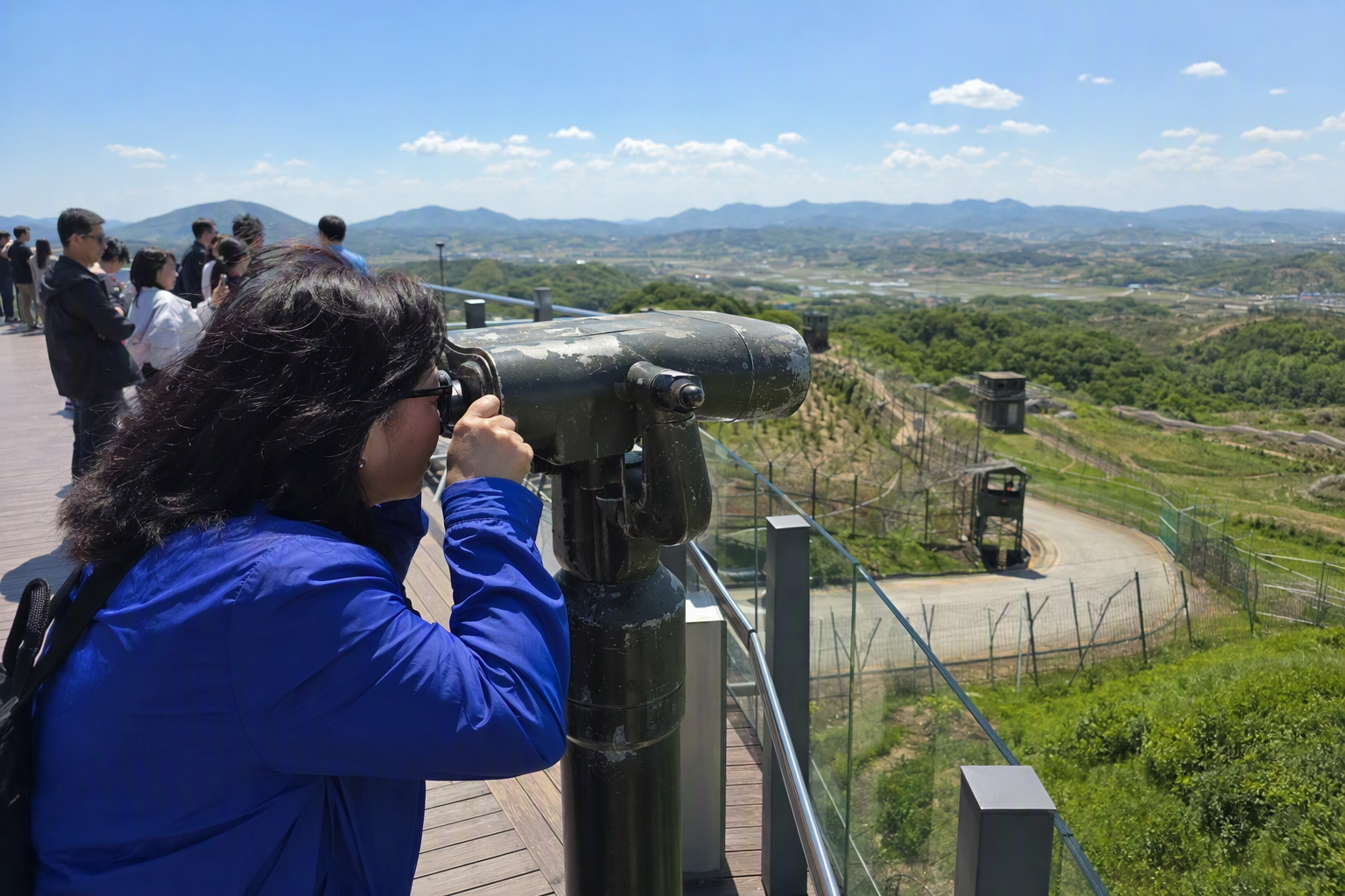 陽光明亮的寫實畫面, 從 DMZ 展望臺望出去, 前景有望遠鏡, 遠方丘陵與平靜天空, 無可見文字