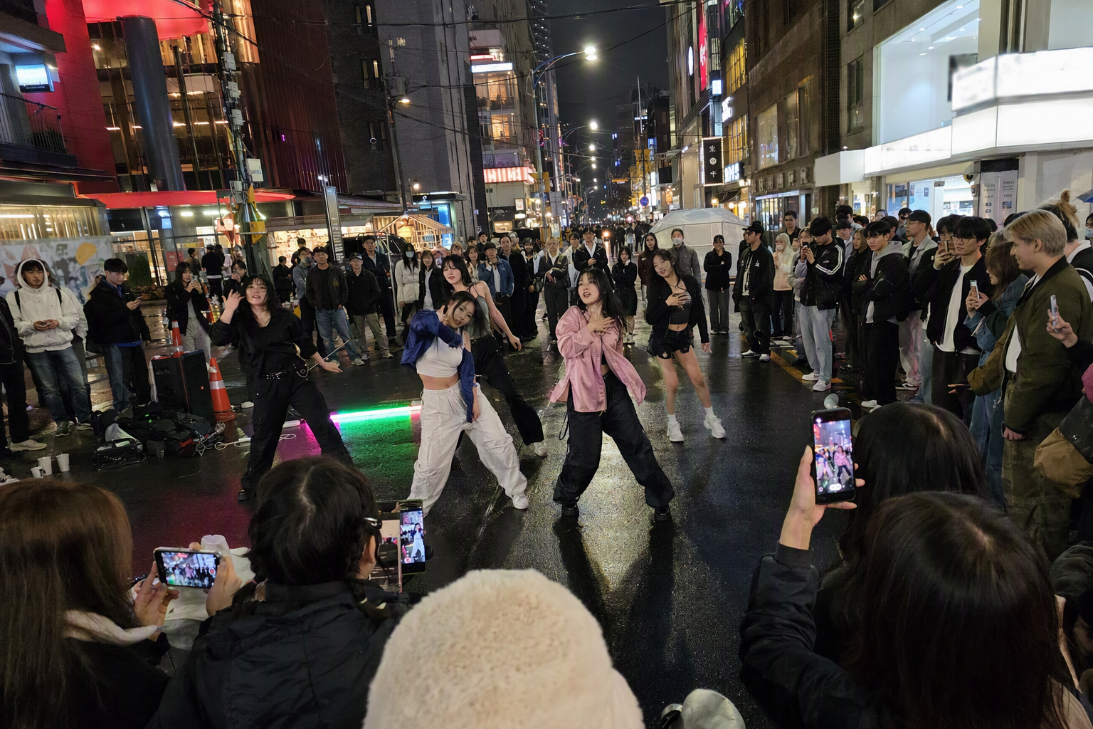 Bright vibrant photorealistic scene of Hongdae busking zone at night, K-pop dance crew performing for a crowd, colorful shop lights, energetic street atmosphere