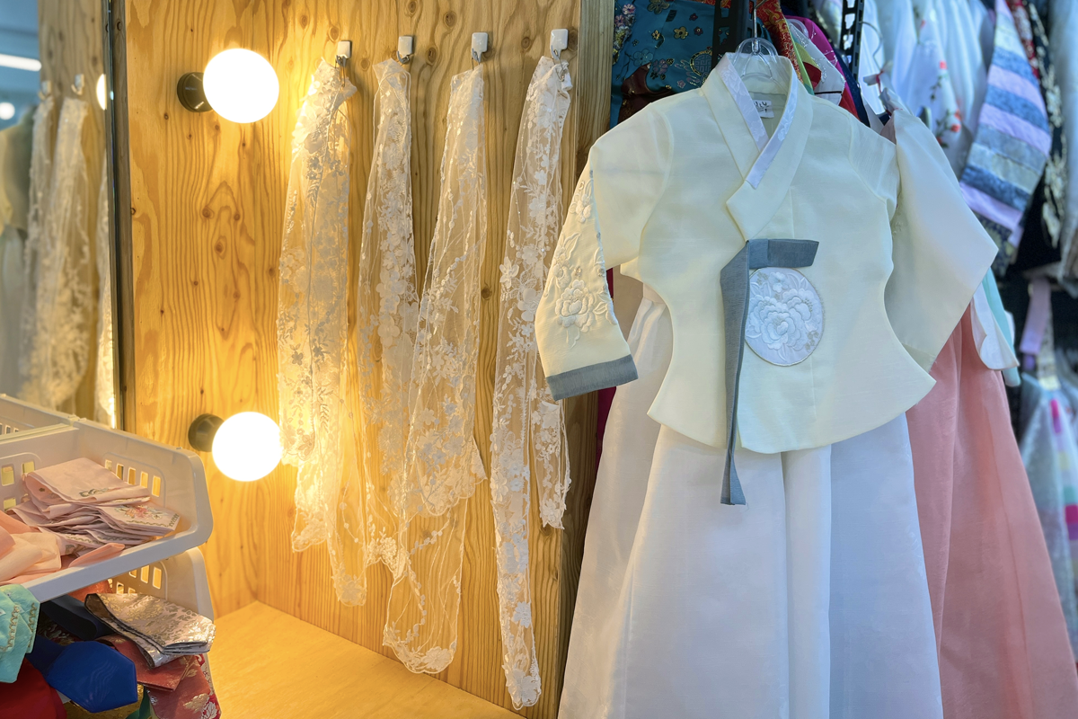 A box of assorted colorful silk ribbons and embroidery patches, neatly organized for accessorizing hanboks at Palace Fox.