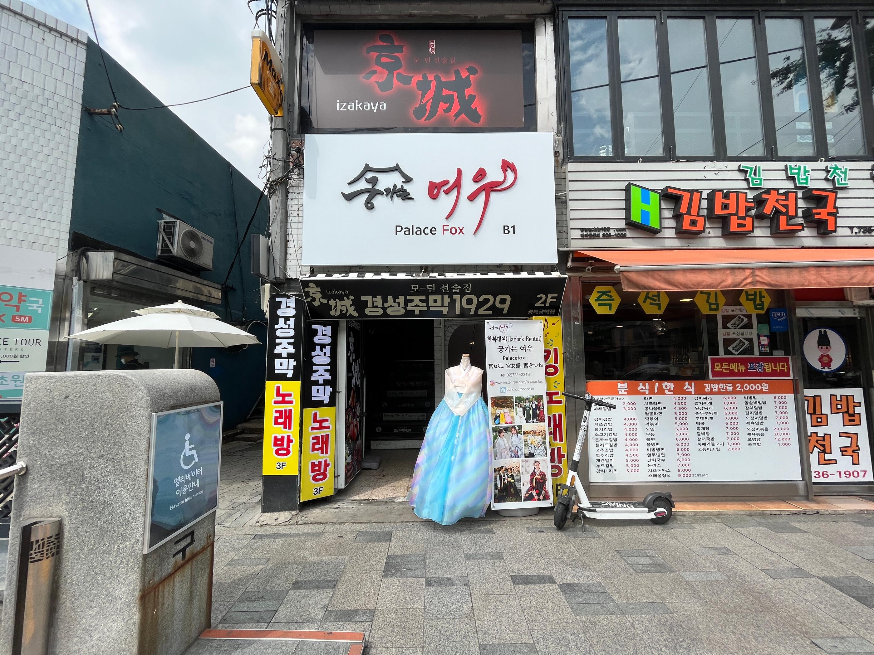 A majestic view of Gyeongbokgung Palace with a person dressed in a traditional hanbok, posing for a photo with the palace gate in the background.