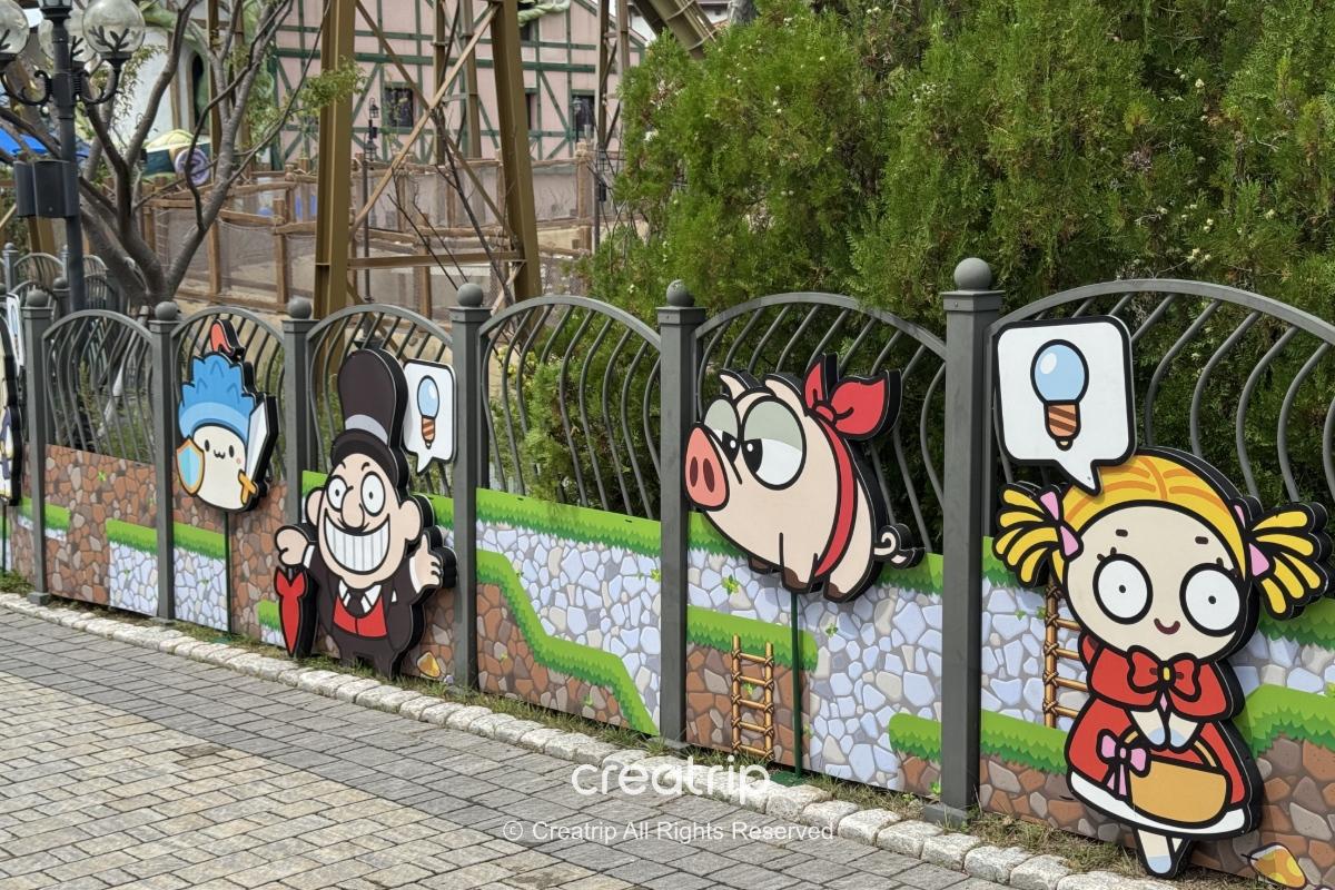 釜山樂天世界楓之谷聯名彩繪圍欄，卡通人物、豬與小鳥等可愛造景排列在步道旁，吸引遊客拍照打卡。
