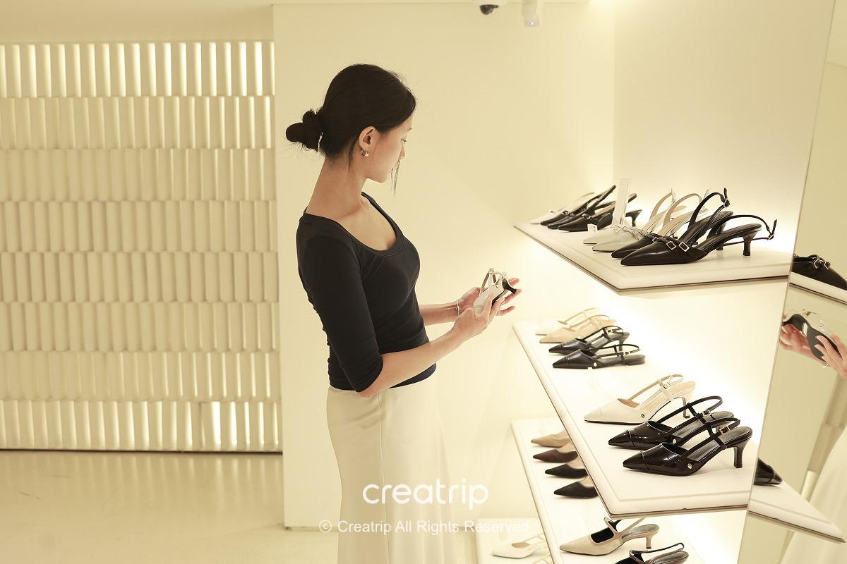 Staff folding the upper section of suede boots to create a mid-calf style
