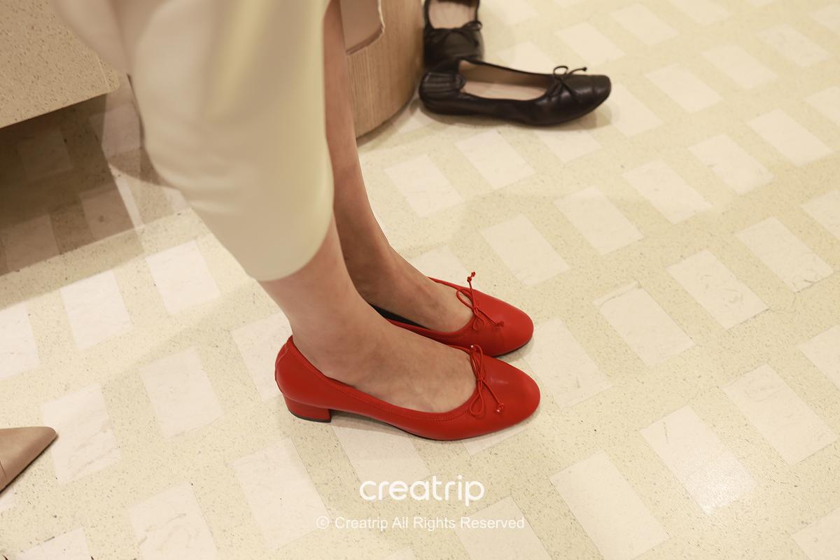Editor trying on black-and-white strap flats inside the SAPPUN store