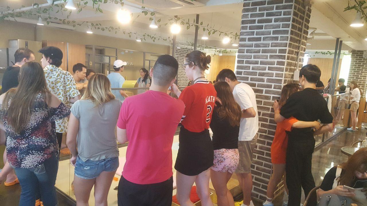 Queue of visitors inside Meerkat Friends café, waiting to enter a meerkat enclosure and enjoy animal interactions.