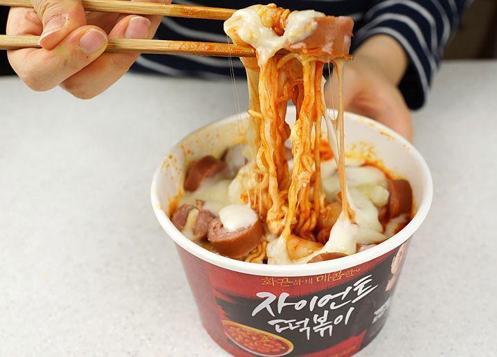 Giant spicy rice cake packaging being held, showcasing one of the main ingredients used in making Mark meal, popular in Korean convenience stores.