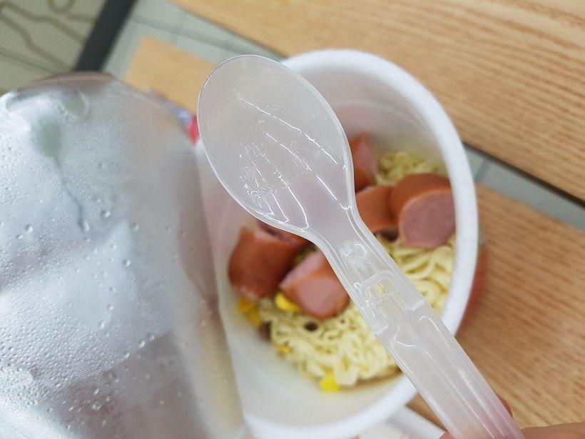 A plastic spoon used to mix and prepare Mark meal, showing convenience in the cooking process.