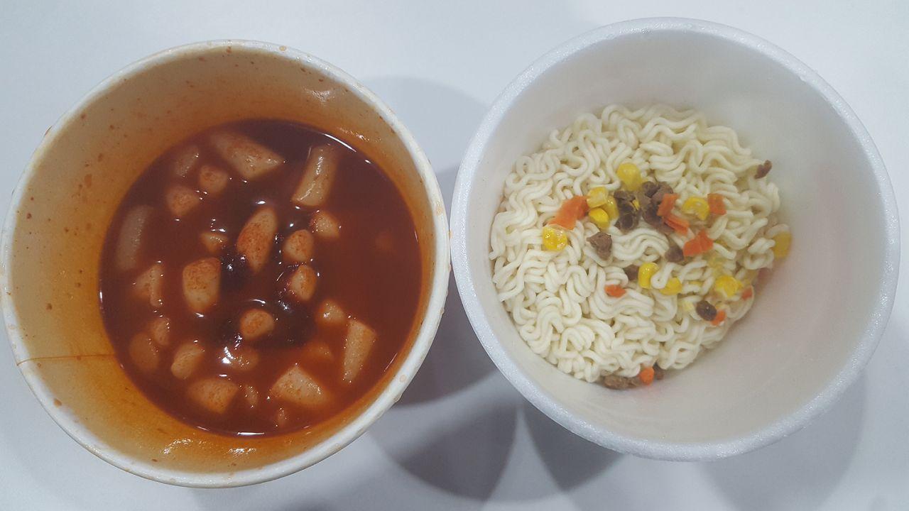Cooked spicy rice cakes and drained noodles, prepared separately as part of the Mark meal process.