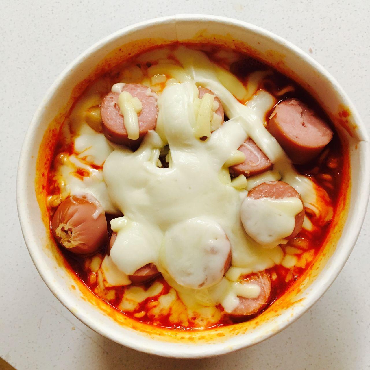 A bowl of Mark meal with visible sausages and melted cheese, appealing to fans of quick, cheesy, and hearty snacks.