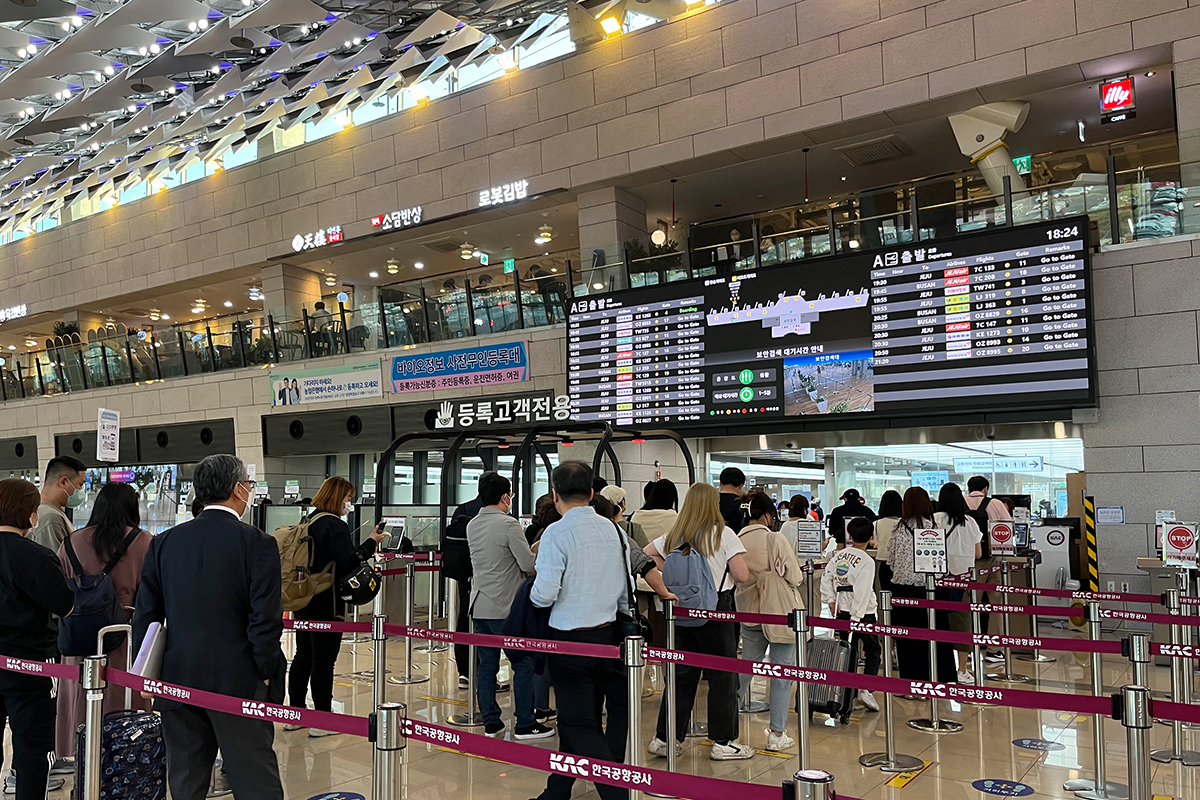 金浦機場內一層內的繁忙登機手續區域，乘客在排隊等候登機。