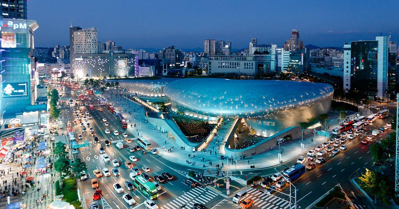 Panoramic night view of Dongdaemun Design Plaza, a landmark in Seoul with modern architecture.