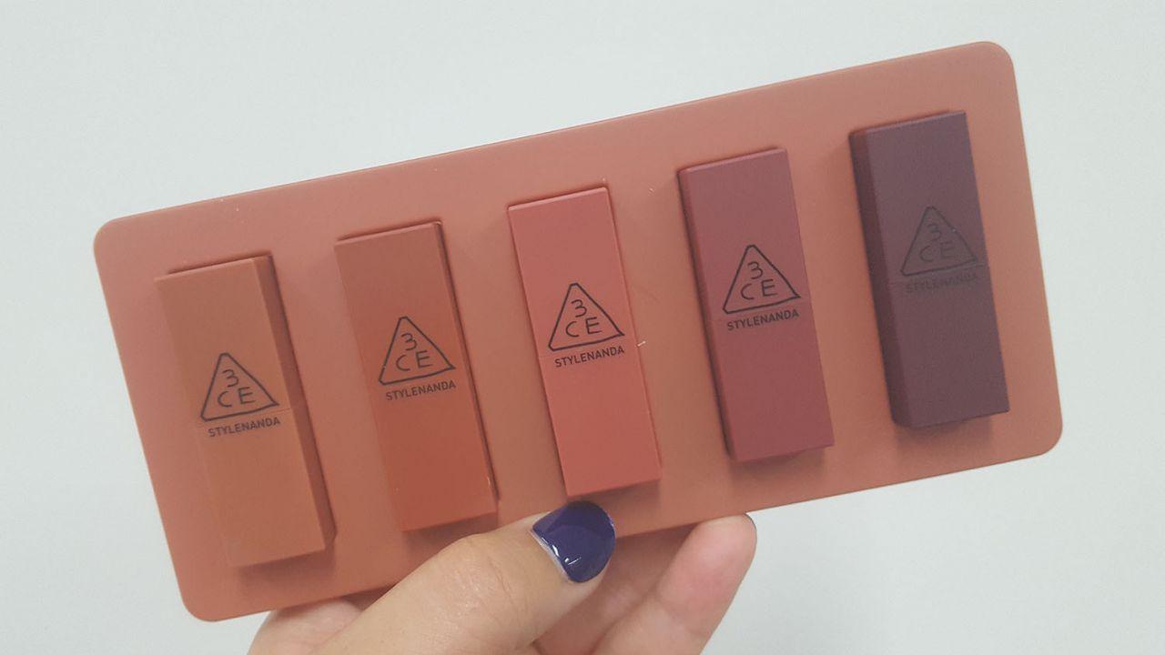 Five 3CE mini lipsticks held apart, showing varied color selections.