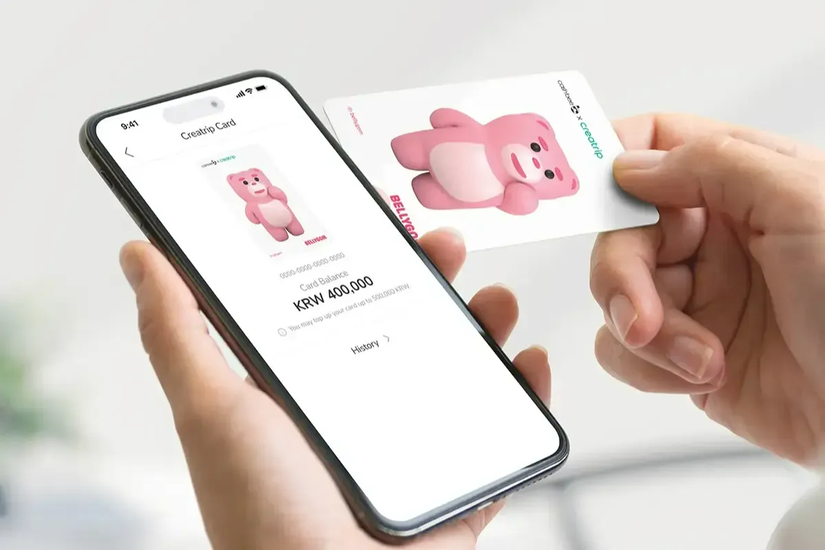 スマートフォンアプリで残高を確認している人とBELLYGOMデザインのキャッシュビー交通カード