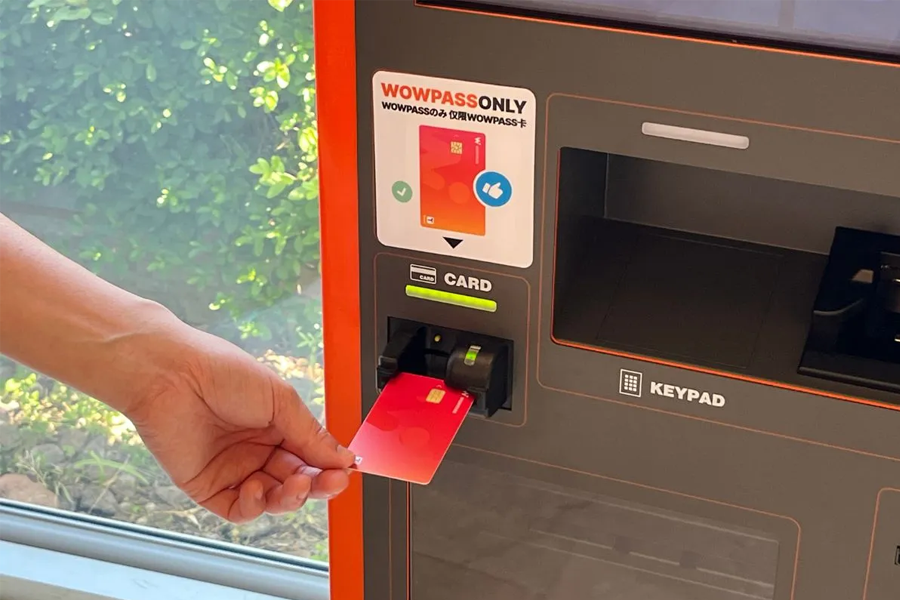 Inserting a card into Wowpass vending machine, demonstrating the card's versatile use in accessing various services.
