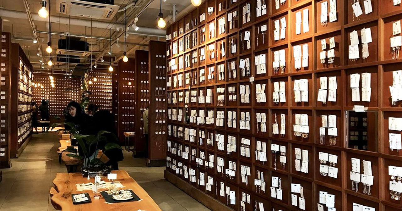 韓國飾品店內部，展示大量飾品的牆面，設有暖色照明，營造舒適購物環境。