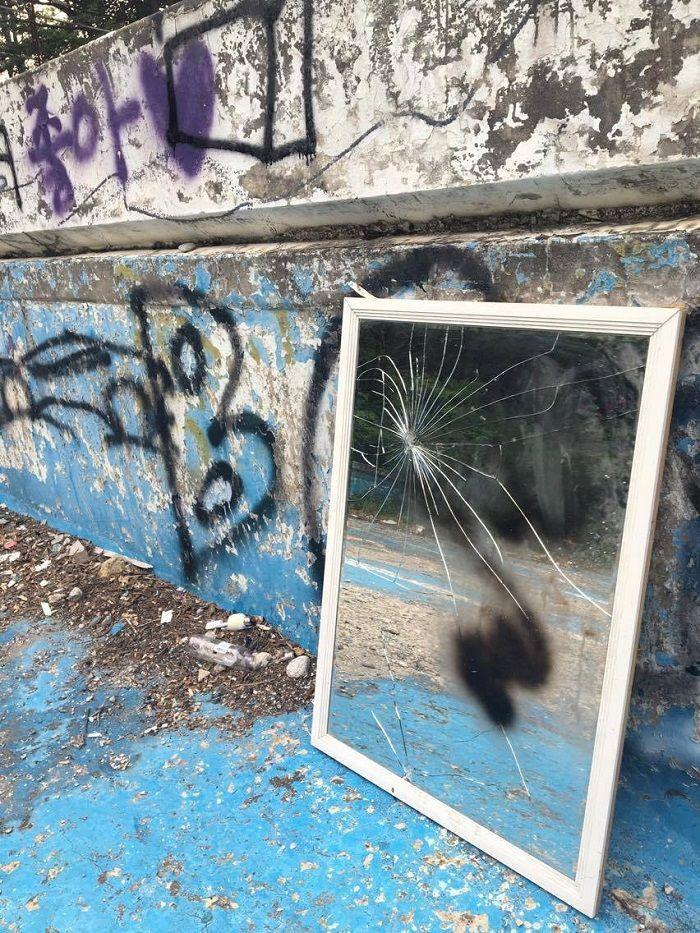 Detailed shot of the abandoned swimming pool showcasing its extensive graffiti art and urban decay.