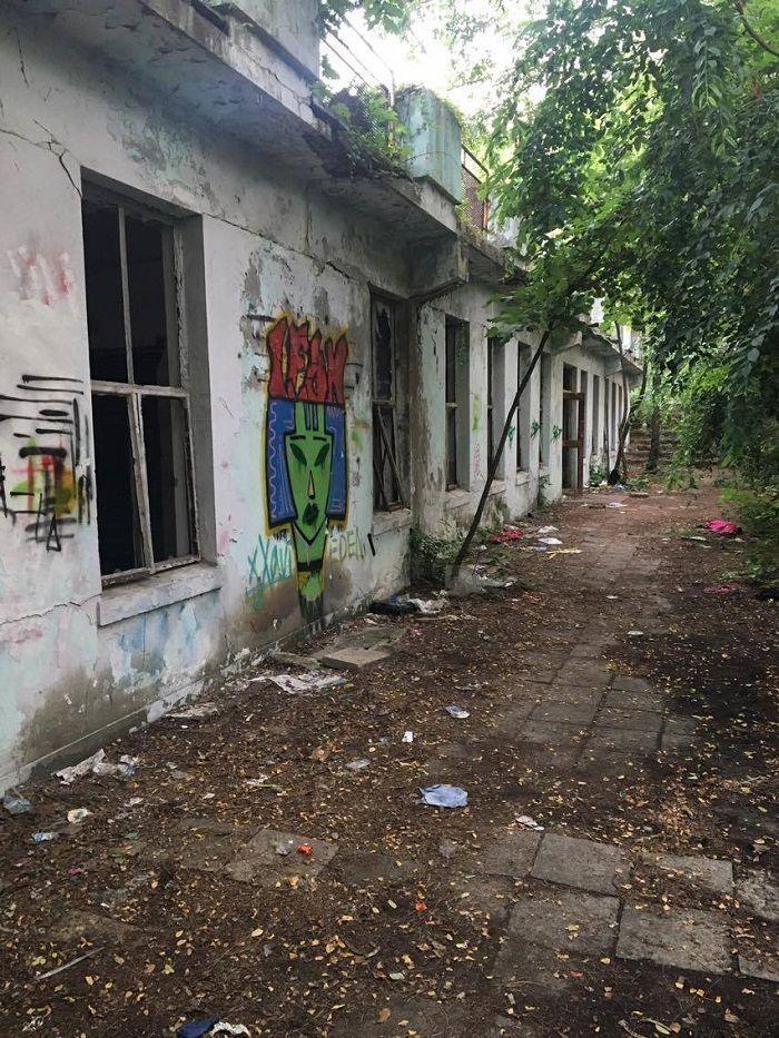 Wide-angle image of the deserted swimming pool at Seoul National University with graffiti-covered walls.