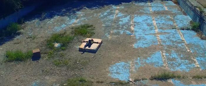 Artistic view of the abandoned swimming pool area with vibrant colors and textures indicative of neglect and artistry.