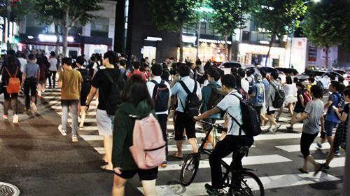 Crowds of students seen crossing a busy street in Gangnam at night after leaving late-night cram schools.