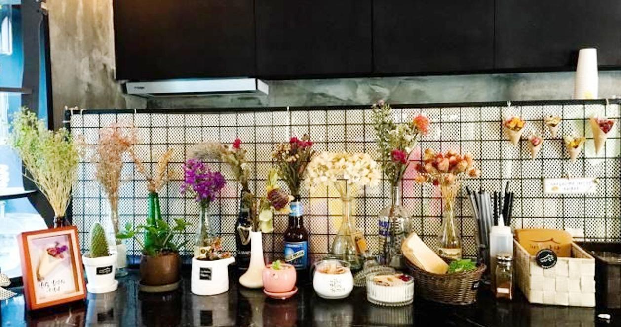 Bên trong quán cafe Barame Salang với bàn trang trí nhiều lọ hoa nhỏ, tạo nên không gian thư giãn với đồ trang trí tinh tế.