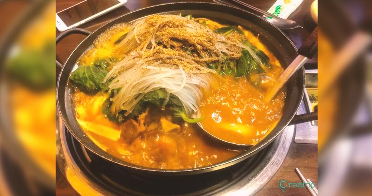 Một bát canh xương heo đầy đủ các nguyên liệu như xương heo, rau và sợi bún tại nhà hàng Sungkyunkwan Gamjatang.