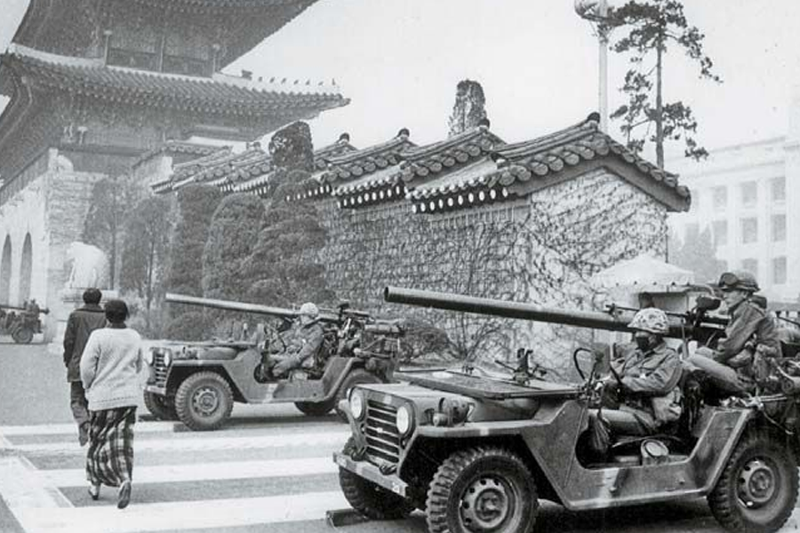 Photo of soldiers in armored jeeps parked near a traditional Korean architecture, indicative of military presence during a state of emergency in South Korea