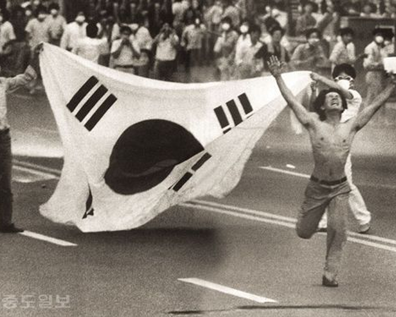 穿著西裝的韓國前領導者，全鬥煥在奢華的室內場景中，背景有韓國的傳統文字掛畫。