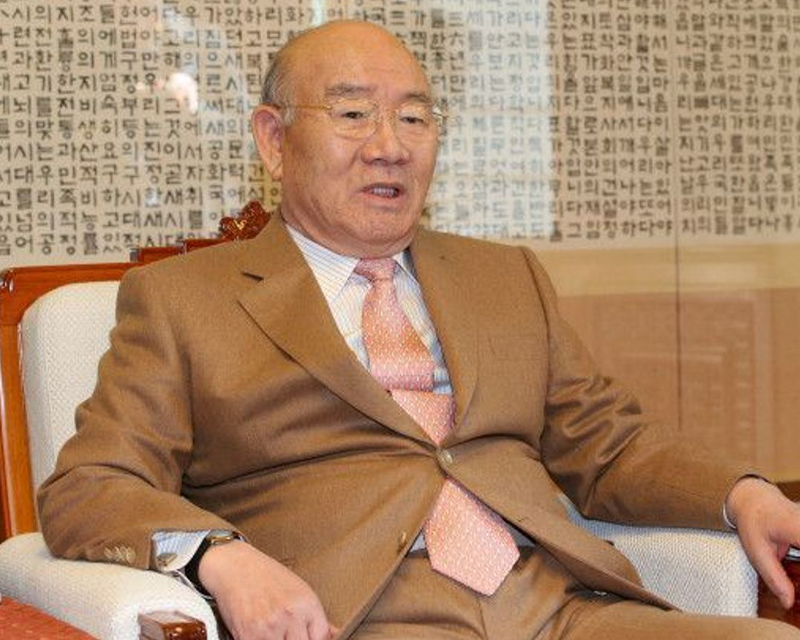 韓國另一位重要的政治人物出現正式場合，背景是一片裝飾壁板，突出領導者的形象。