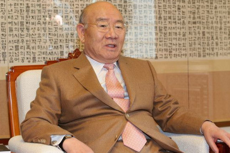 A man in a suit sitting in an office setting, a significant figure related to Korean political history