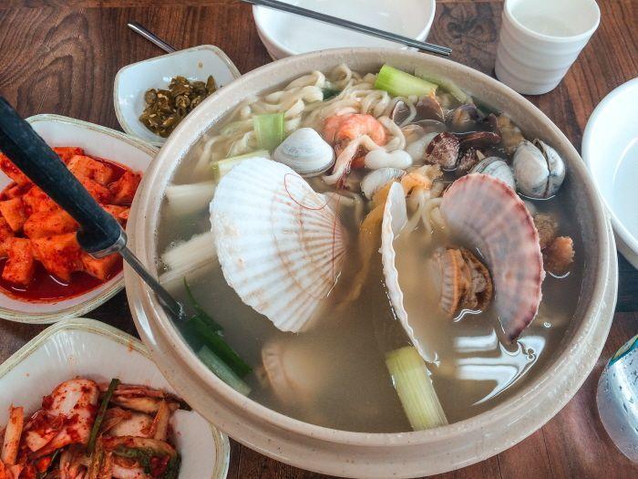 A large bowl of seafood noodle soup served at the famous Huanghai Seafood Kalguksu restaurant.