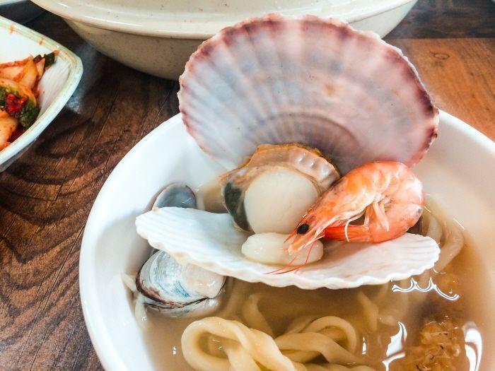 Close-up of the seafood and noodle dish with various shellfish and shrimp.