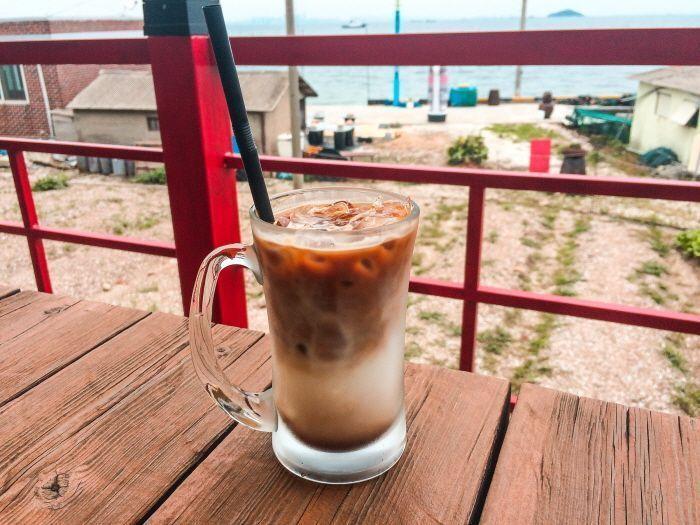 A cute kitten sitting under a table at the outdoor café.
