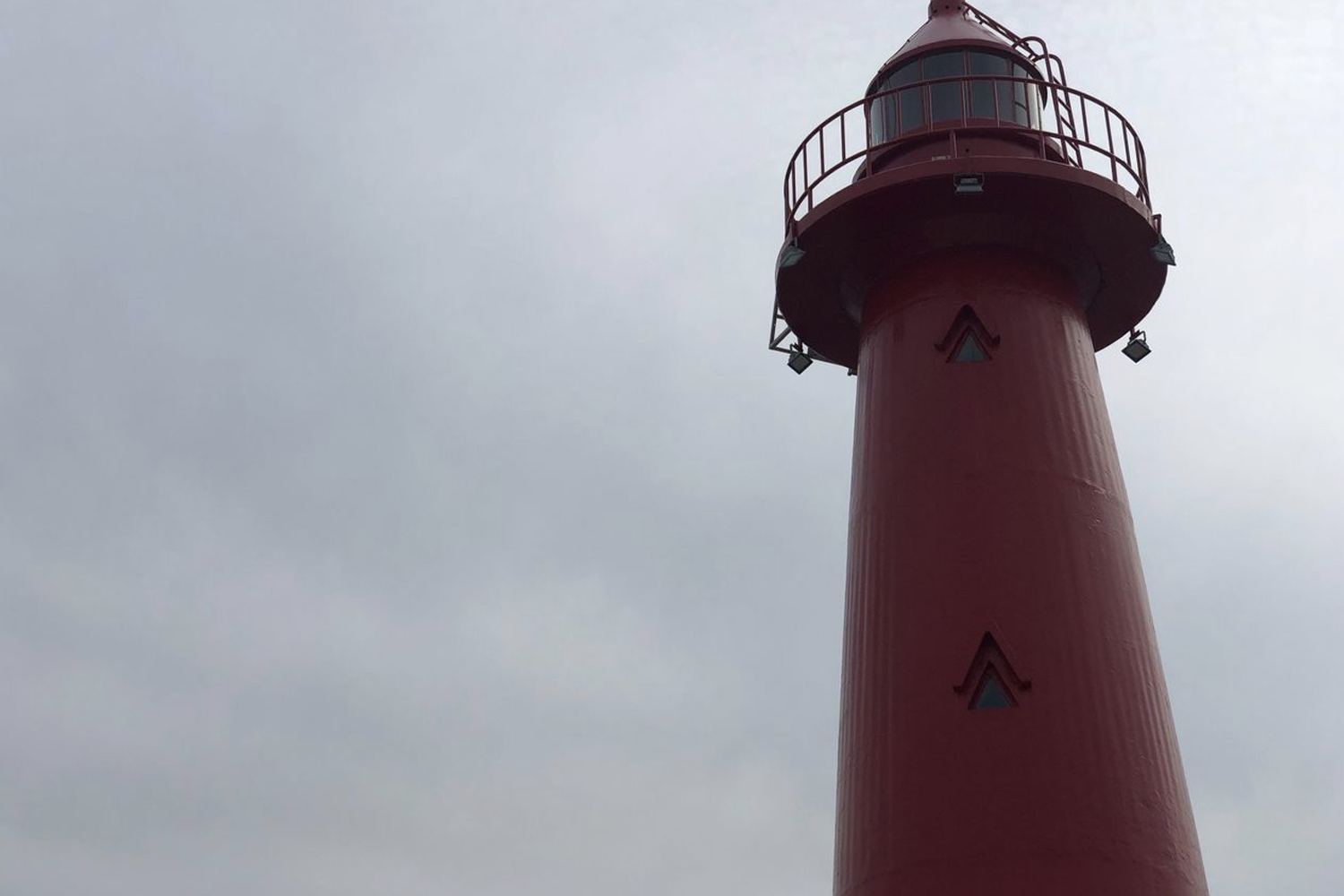 釜山青沙浦紅燈塔，藍天白雲下的地標性建築。