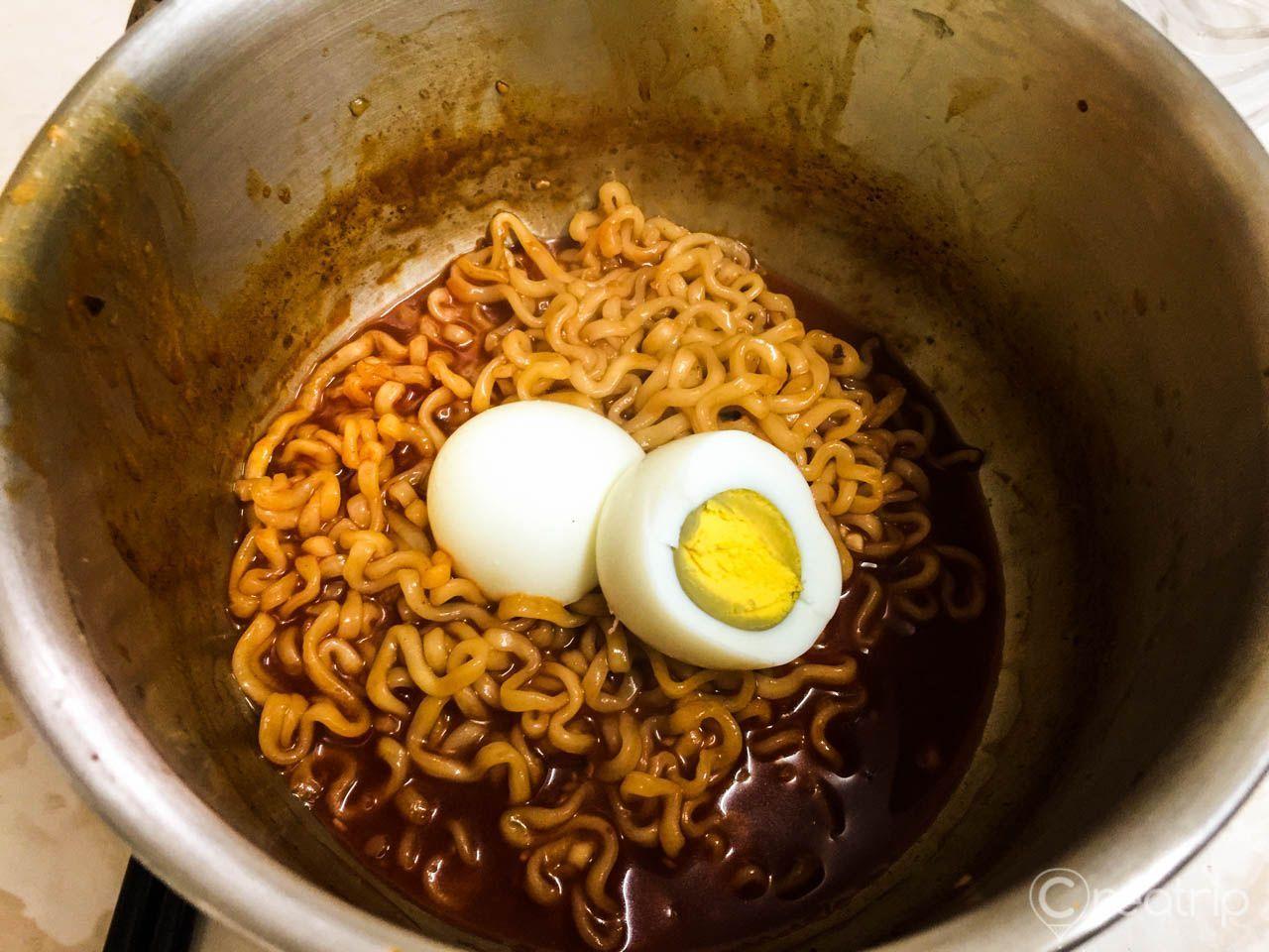 在鍋中加入水煮蛋，與辣炒雞麵的醬料攪拌在一起，增添滋味的同時也美味可口。